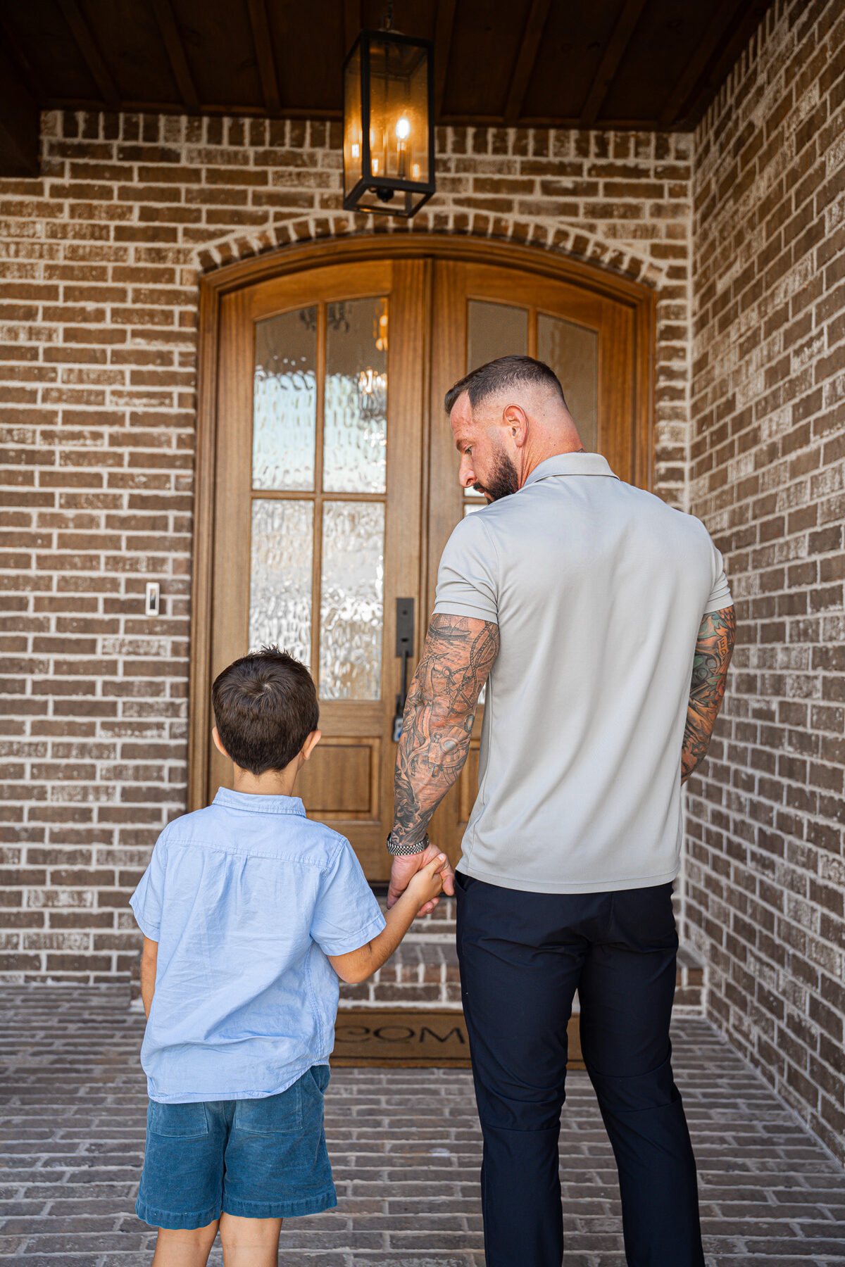 Caleb Scott and his son at the front door of a home